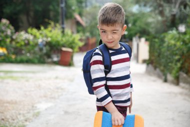 Çizgili elbiseli şirin çocuk dışarıda göz kırpıyor..