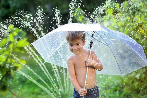 Little Cute Dziecko Bawi Się Parasolem Strumieniem Wody Ogrodzie — Zdjęcie stockowe