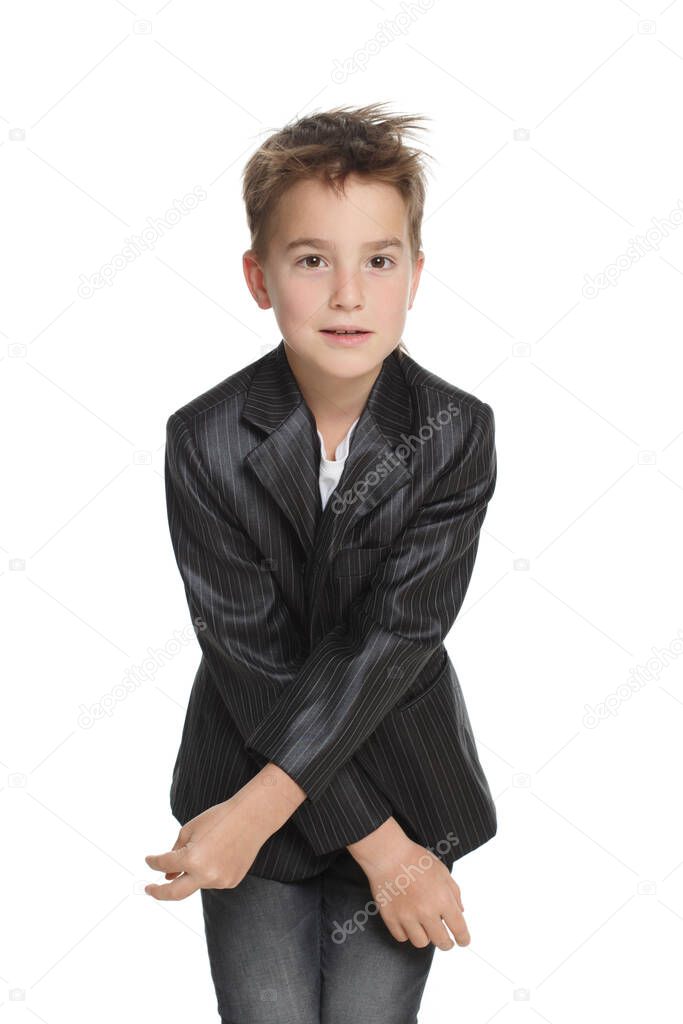 Little cute emotional boy in a jacket closes with his arms crossed in front of him isolated on a white background.