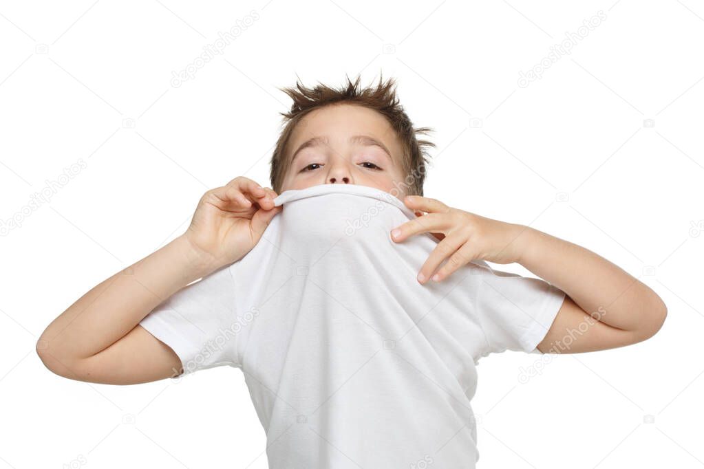 Little emotional boy in a white T-shirt peeps out of the gate Isolated on a white background.