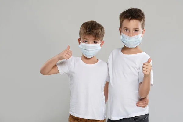 Zwei Niedliche Kleine Jungen Weißen Kleidern Und Medizinischen Schutzmasken Zeigen — Stockfoto
