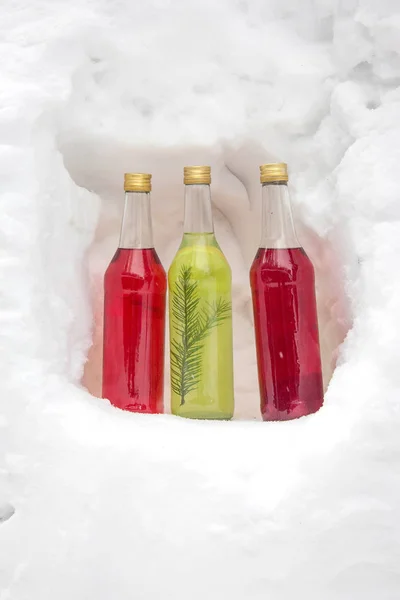 Multi-colored bottles.Bottles with alcohol in the snow