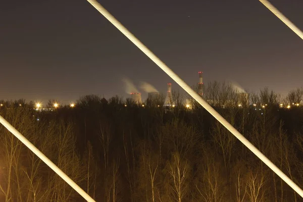 Gece ufukta endüstriyel borular beliriyor.
