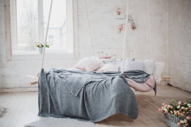 farklı yastıklar ve renkli kareli asılı rahat yatak 