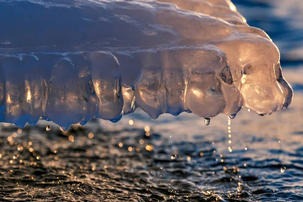 Icicle au coucher du soleil avec des gouttes d'eau — Photo