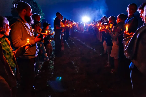 BOLSHAYA RECHKA, RUSSIA - JUNE 25 2017: Celebrating of Belorussian holiday Ivan Kupala near the river Angara by community Krivichi, people with candles meeting singers at night — Stock Photo, Image