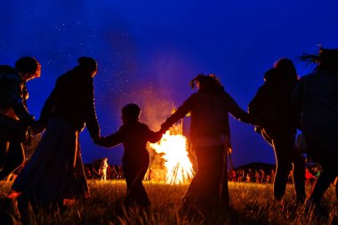 Bolshaya Rechka, Rusya - 24 Haziran 2017: Angara Nehri yakınlarındaki Beyaz Rusya tatiliivan Kupala'yı kutlamak, topluluk Krivichi tarafından, daire dansı yapan insanların siluetleri