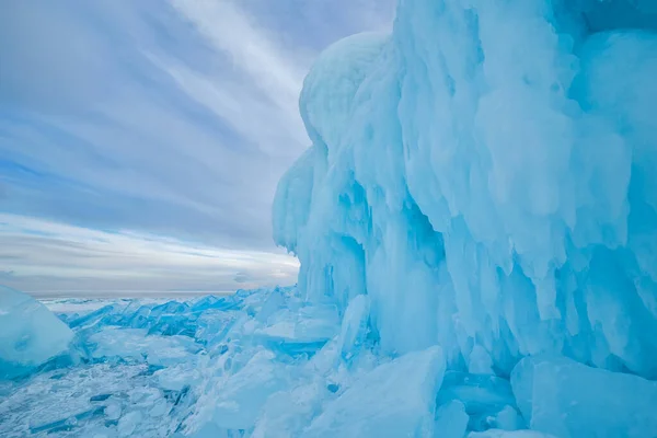 Klippig med blå is och många glaciärbitar nedanför — Stockfoto