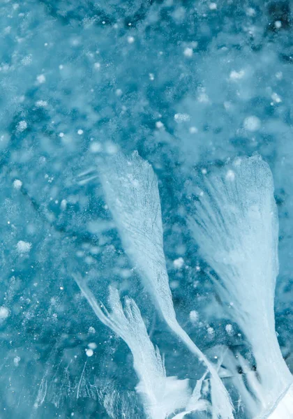Rachaduras abstratas no gelo de lago congelado em forma de penas — Fotografia de Stock