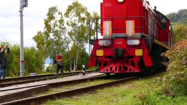 SHARIZHALGAY, RUSSIE - 13 SEPTEMBRE 2019 : Le train de voyageurs rouge commence à circuler sur le circuit ferroviaire baikal. — Video