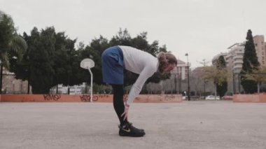 Basketbolcu antrenmandan önce ısınır.