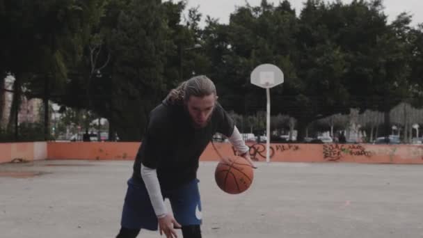 schöner Mann spielt Basketball im Freien