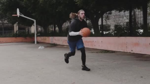 Lanzar una pelota en un aro de baloncesto, vista frontal — Vídeo de stock