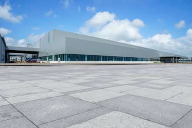 Boş kare döşemeler, modern fabrika binaları ve ambar.