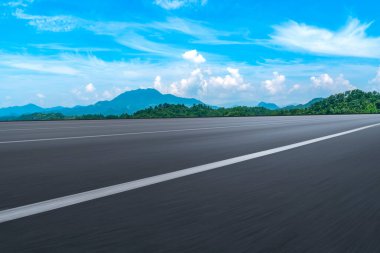 Boş asfalt yol ve mavi gökyüzünün altındaki doğal manzara