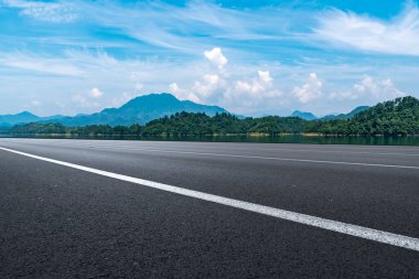Boş asfalt yol ve mavi gökyüzünün altındaki doğal manzara