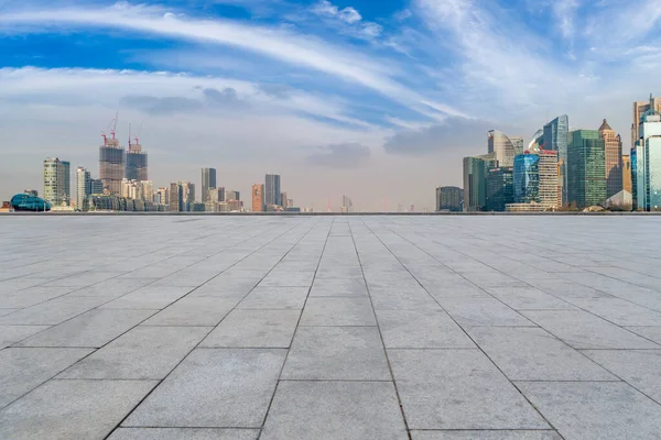 空の正方形の床のタイルと都市の高層ビル — ストック写真