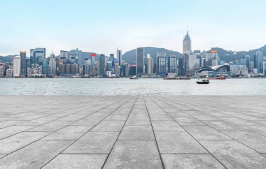 Boş mermer zemin ve mavi gökyüzünün altındaki şehir manzarası.