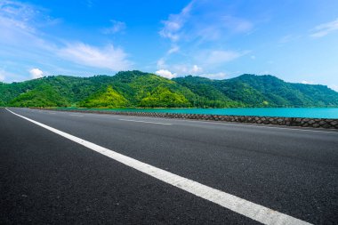 Boş asfalt yol ve mavi gökyüzünün altındaki doğal manzara