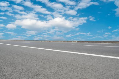 Boş asfalt yol ve mavi gökyüzünün altındaki doğal manzara