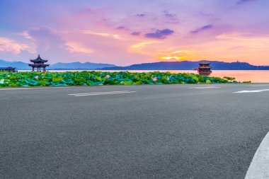 Boş asfalt yol ve batan güneşte doğal manzara