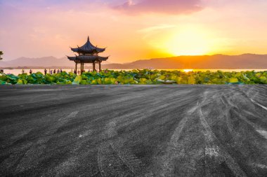 Boş asfalt yol ve batan güneşte doğal manzara