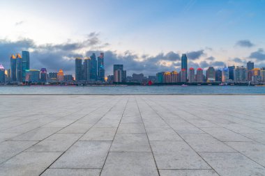 Boş mermer zemin ve mavi gökyüzünün altındaki şehir manzarası.