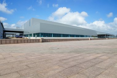 Yol asfaltı kaldırımı ve modern fabrika deposu.