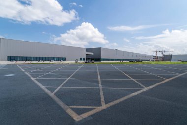 Yol asfaltı kaldırımı ve modern fabrika deposu.