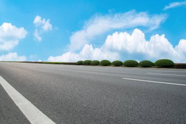 Mavi gökyüzü ve beyaz bulutların altında yol kaldırımı