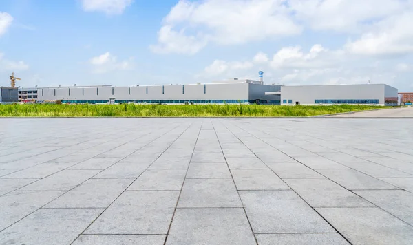 Boş kare döşemeler, modern fabrika binaları ve ambar.