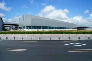 Yol asfaltı kaldırımı ve modern fabrika deposu.