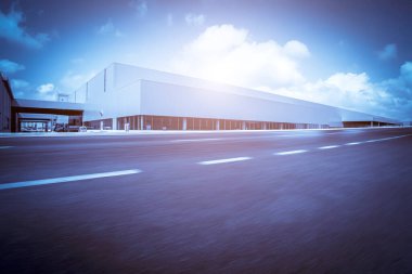 Yol asfaltı kaldırımı ve modern fabrika deposu.