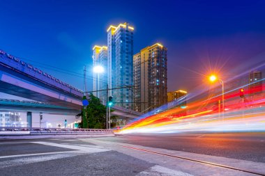 Kentsel üstgeçitin gece manzarası ve bulanık araba ışıkları.