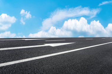 Mavi gökyüzü ve beyaz bulutların altında yol kaldırımı