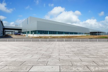 Boş kare döşemeler, modern fabrika binaları ve ambar.