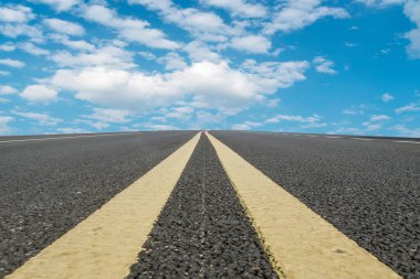Boş asfalt yol ve mavi gökyüzünün altındaki doğal manzara