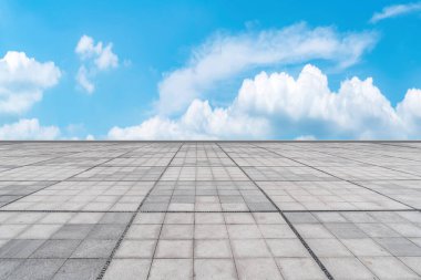 Empty stone floor under blue sky and white clouds clipart