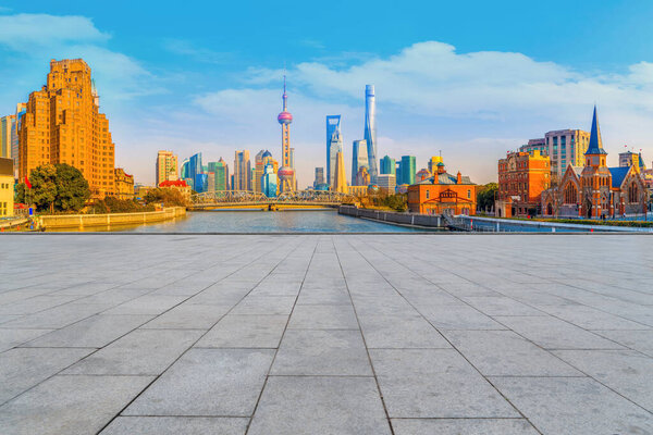 Голубое небо, пустой мраморный пол и горизонт шанхайских городских архи
