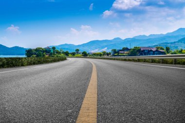 Boş asfalt yol ve mavi gökyüzünün altındaki doğal manzara