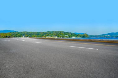 Boş asfalt yol ve mavi gökyüzünün altındaki doğal manzara