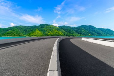 Boş asfalt yol ve mavi gökyüzünün altındaki doğal manzara