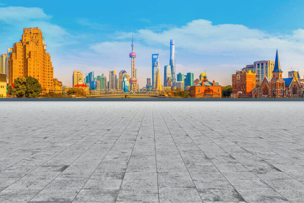 Голубое небо, пустой мраморный пол и горизонт шанхайских городских архи
