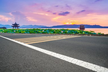 Boş asfalt yol ve batan güneşte doğal manzara