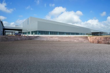 Yol asfaltı kaldırımı ve modern fabrika deposu.