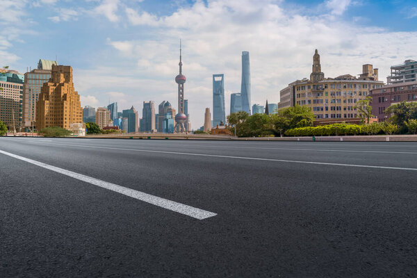Empty asphalt road along modern commercial buildings in China's