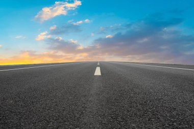 Boş asfalt yol ve batan güneşte doğal manzara