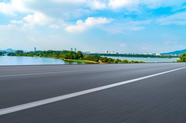 Boş asfalt yol ve mavi gökyüzünün altındaki doğal manzara