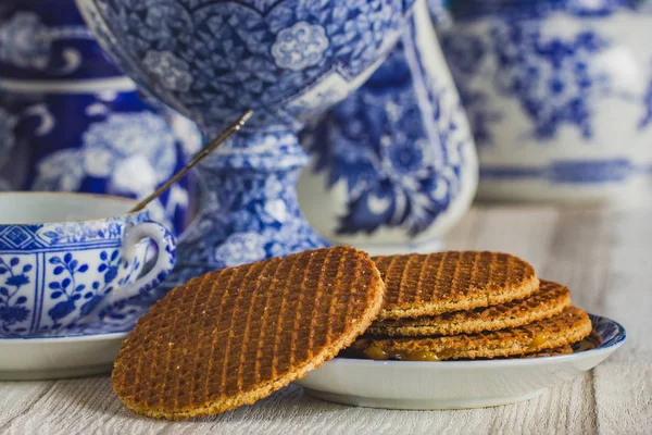 Geleneksel Hollanda stroopwafel şurup, kurabiye ve çay ile Delfts dekoratif çanak çömlek koymak tablo, yakın çekim, makro fotoğraf mavi.