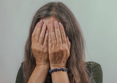 Kapalı bir alanda yüzü kapalı umutsuz bir kadın. Duygular ve sorunlar kavramı.